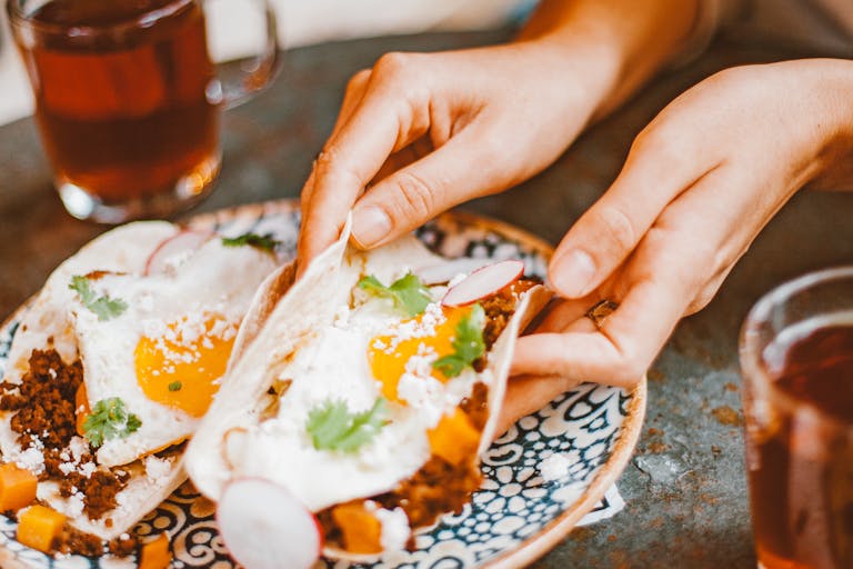 A vibrant close-up of breakfast tacos with fried eggs, perfect for food lovers.